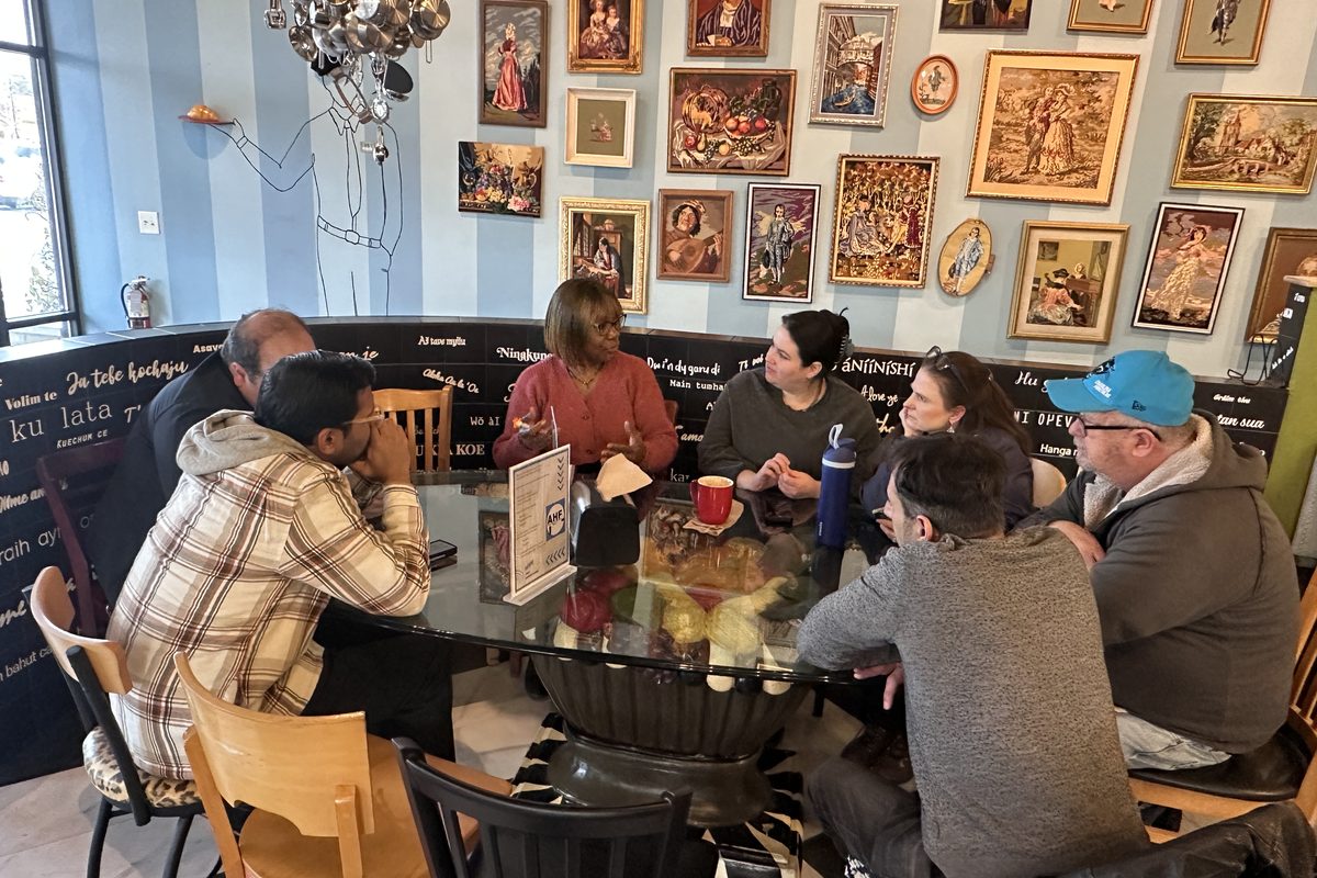 AHF local meetup — members in conversation around a café table